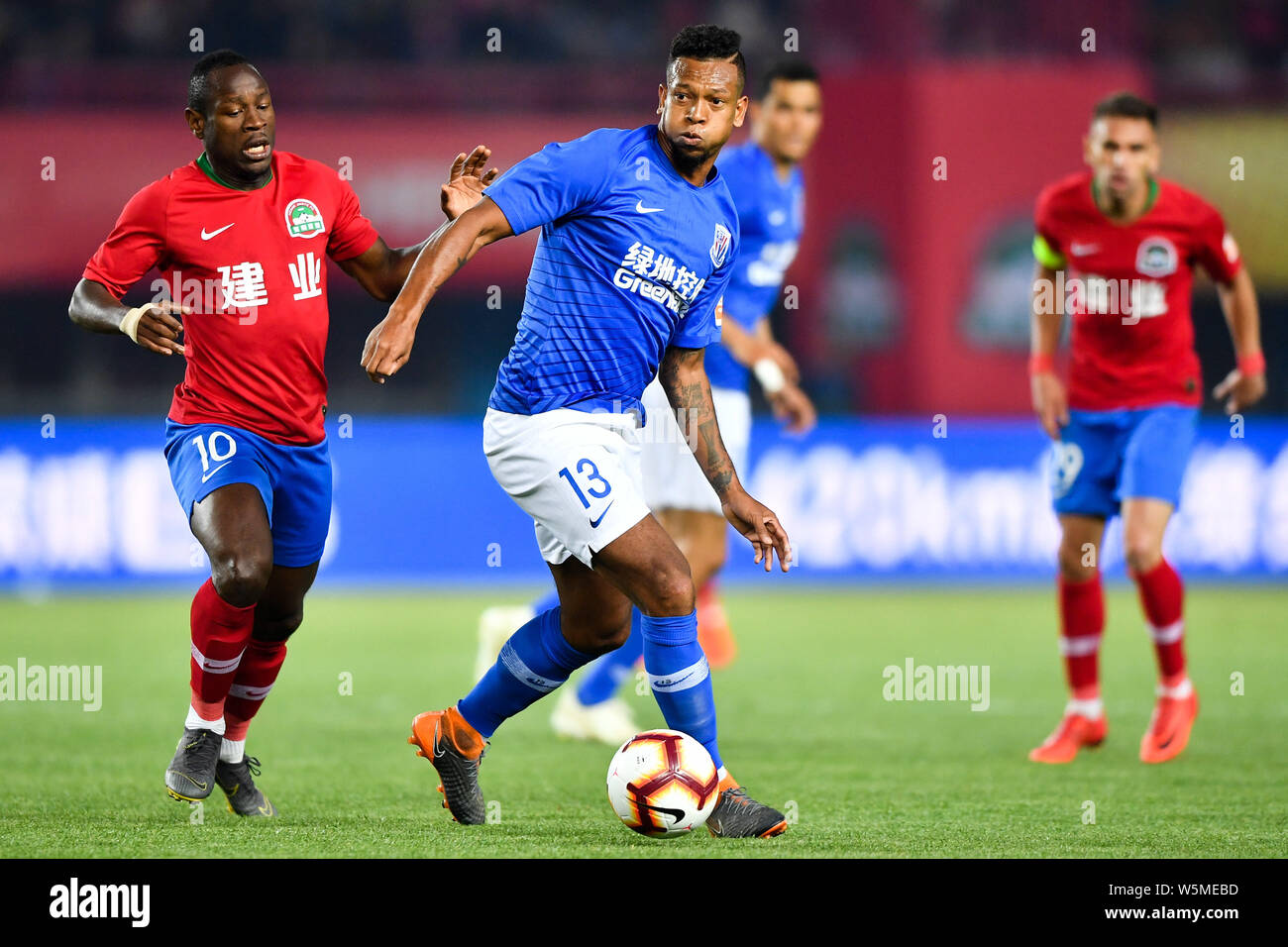 Colombian football player Fredy Guarin, right, of Shanghai Greenland Shenhua passes the ball against Cameroonian football player Christian Bassogog of Stock Photo