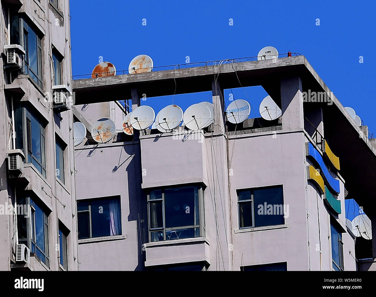 A residential building is installed with satellite TV receiver dishes in Shenyang city, northeast China's Liaoning province, 2 April 2019. Stock Photo