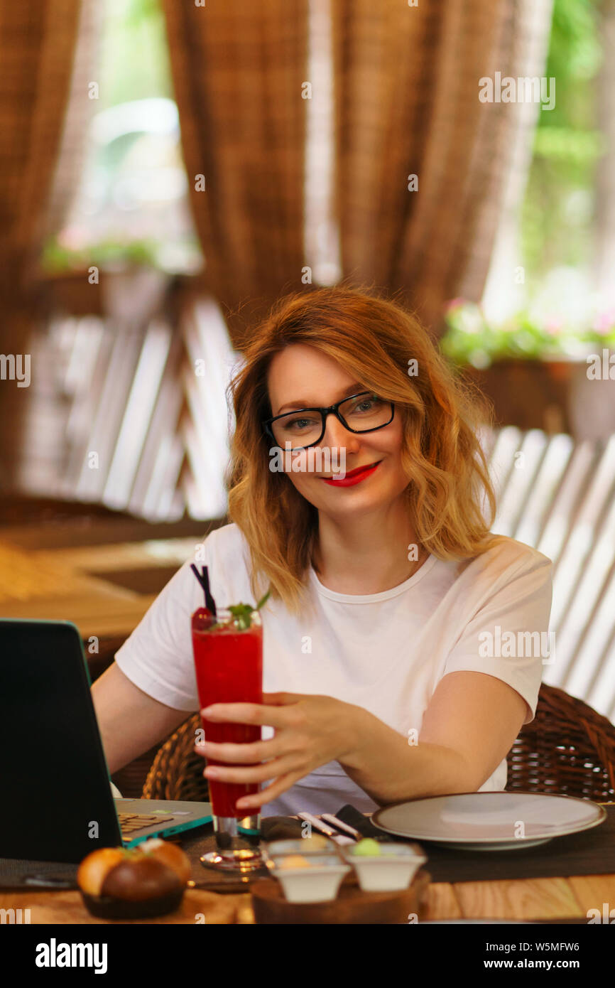 Business lady received compliment from restaurant. She enjoys refreshing non-alcoholic cocktail on restaurant’s summer terrace. Work will wait. Busine Stock Photo