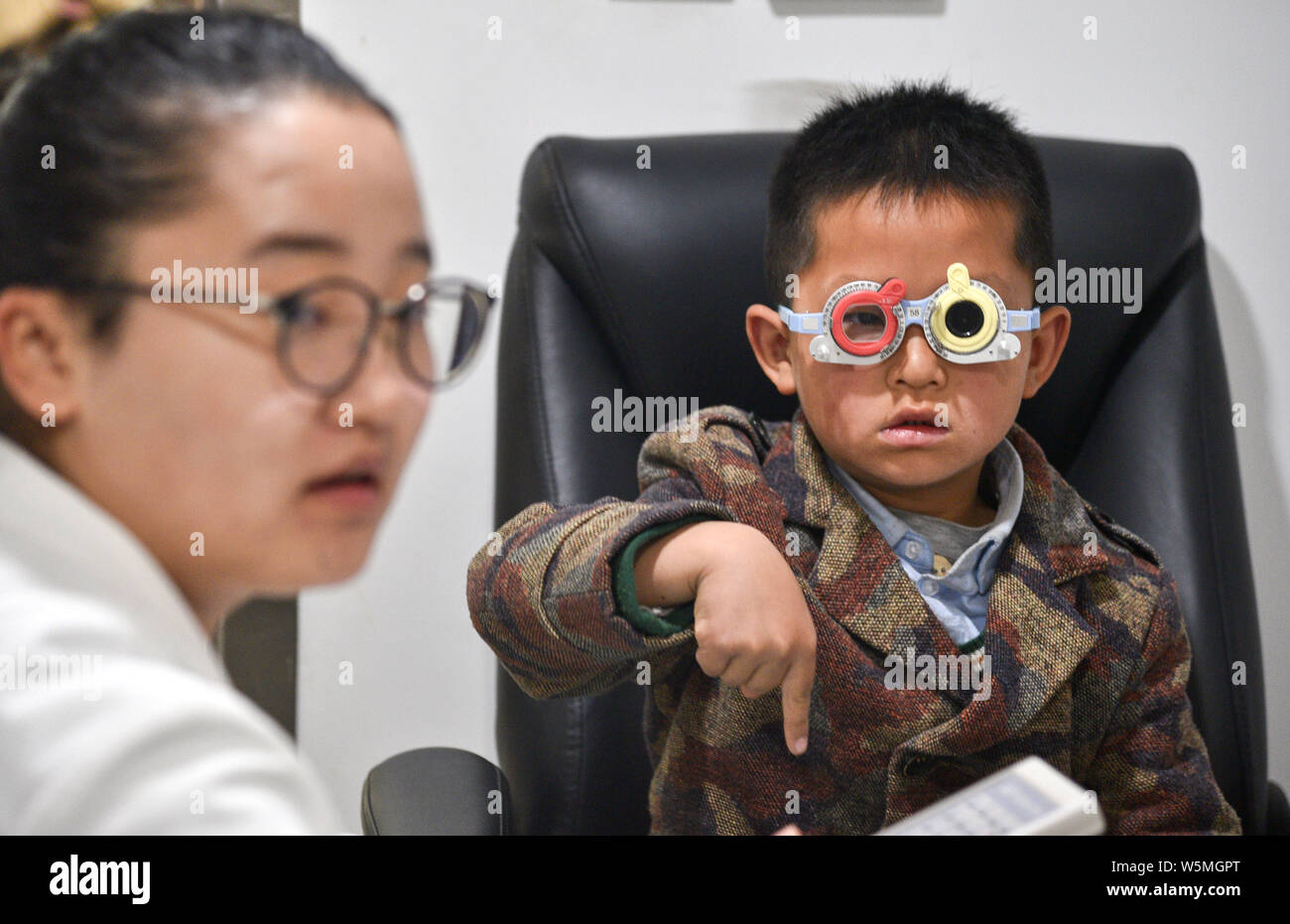 --FILE--A Chinese doctor tests the eyesight of a young boy at an eye hospital in Xi'an city, northwest China's Shaanxi province, 22 March 2019.   Acco Stock Photo