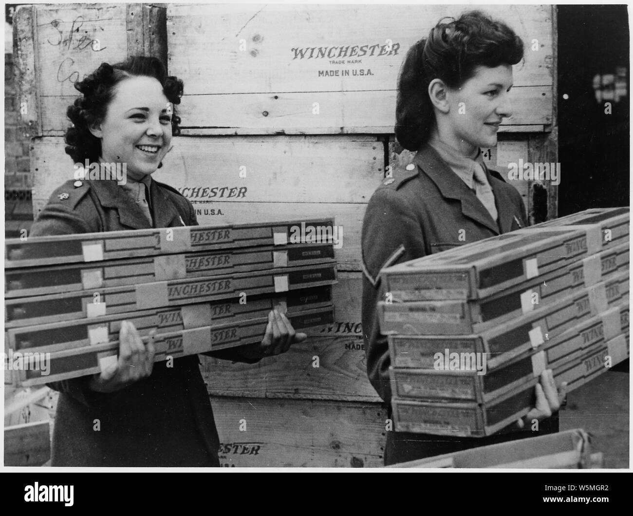 English girl members of the Auxiliary Territorial Service move armfuls ...