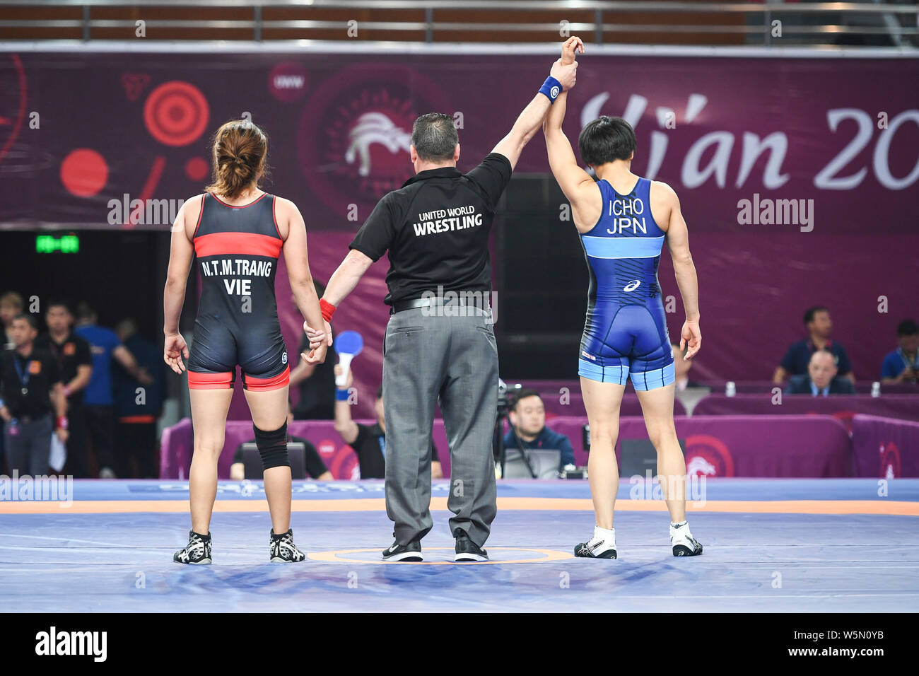 Kaori Icho of Japan, right, is announced as the winner by the referee after defeating N.T.M. Trang of Vietnam in the women's 57kg wrestling during the Stock Photo
