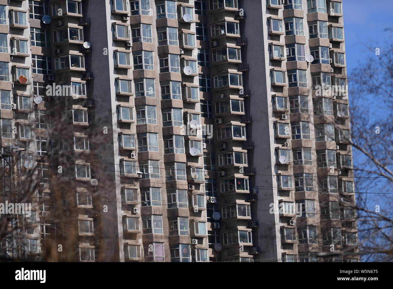 A residential building is installed with satellite TV receiver dishes in Shenyang city, northeast China's Liaoning province, 2 April 2019. Stock Photo