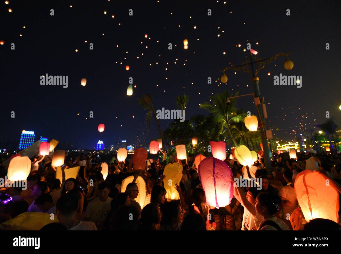 Tourists and people of Dai ethnic group release sky lanterns, also ...