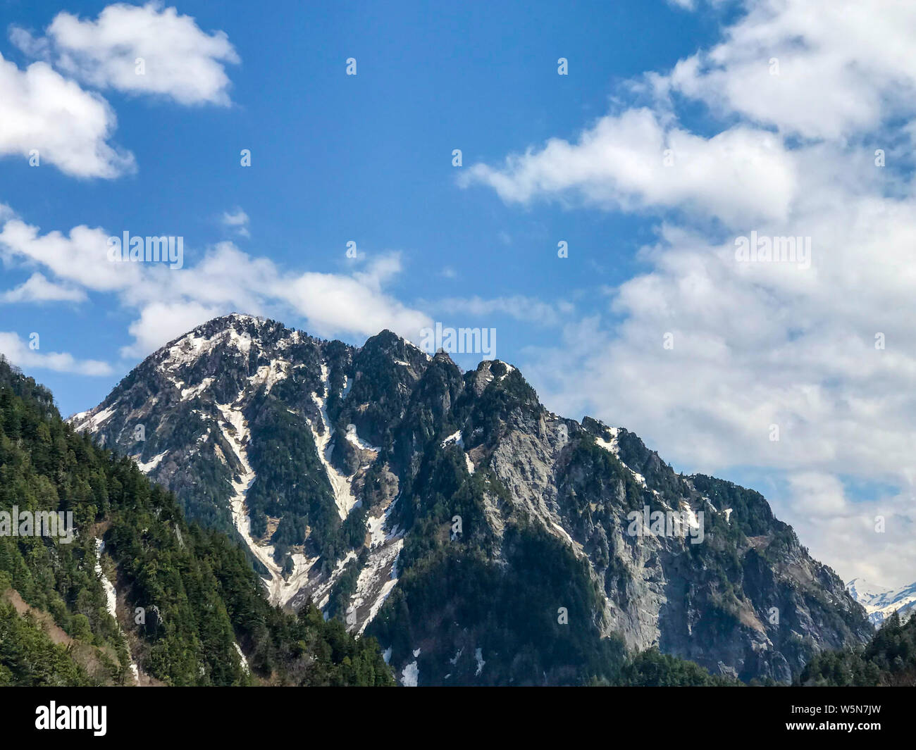 Beautiful snow mountain view with blue sky and cloud on Tateyama Kurobe alpine route, Japanese alps in Japan. Stock Photo