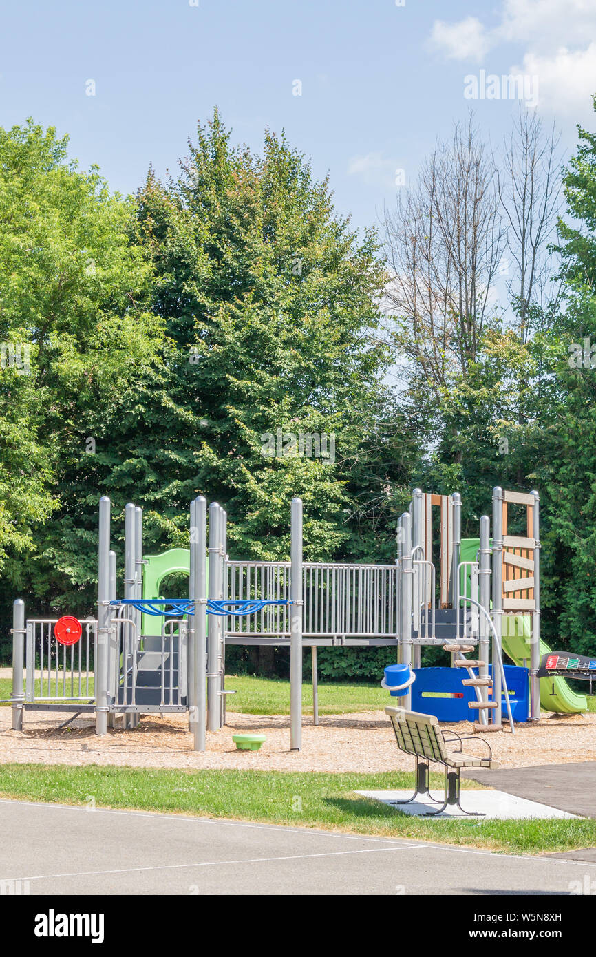 A kids' playground in an outdoor park awaits kids in the summer. Stock Photo