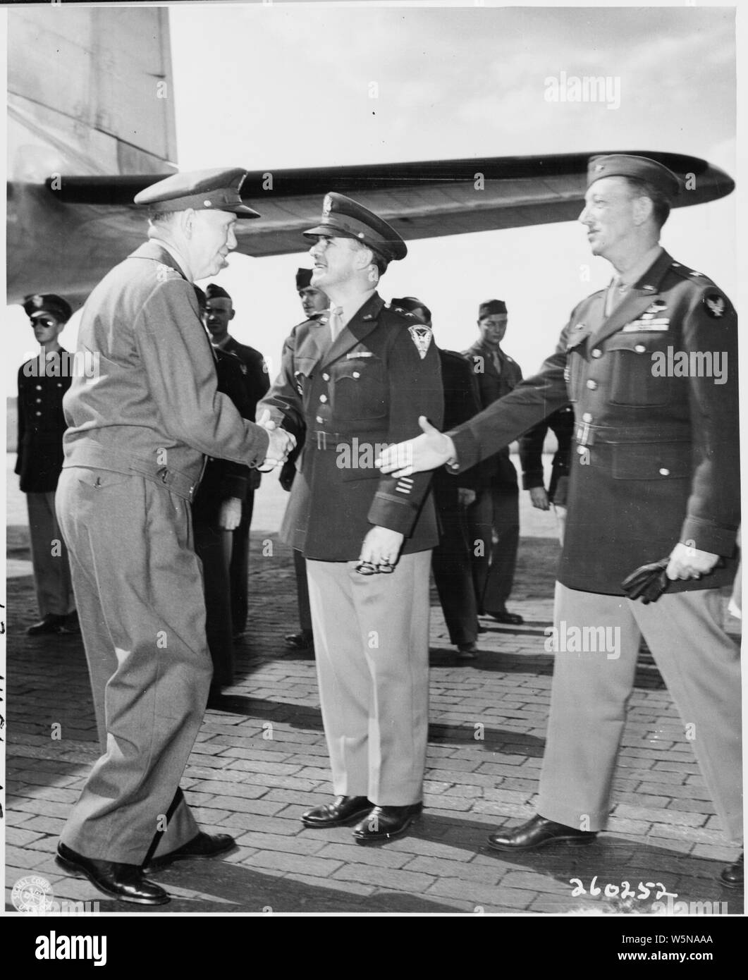 Gen. George C. Marshall shakes hands with Maj. Gen. John R. Deane, center, as Brig. Gen. Ben Stewart Cutler extends his hand in greeting at Gatow Airport in Berlin, Germany at the beginning of the Potsdam Conference. Stock Photo