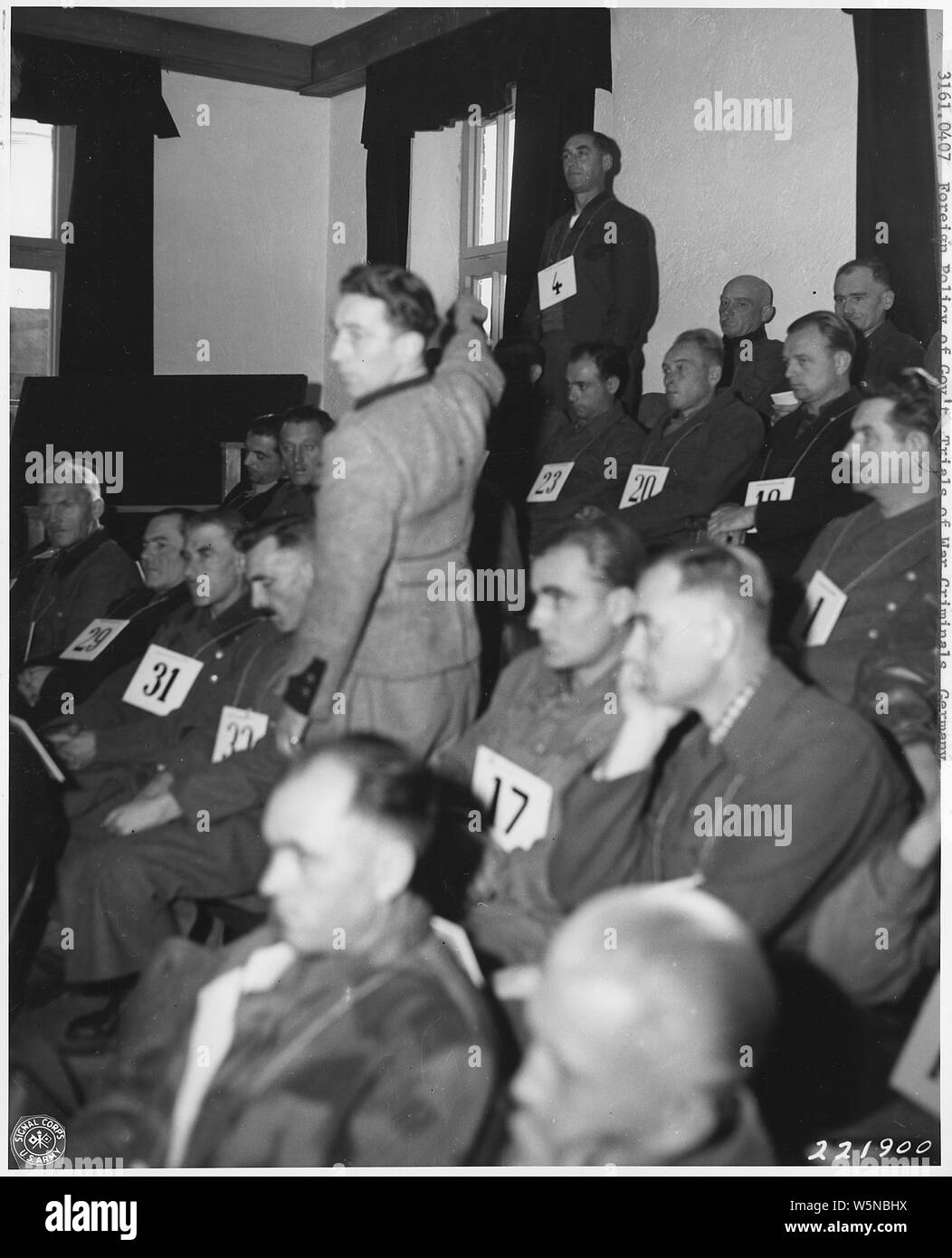 German War Crimes Trials. Nuernberg & Dachau; Scope and content:  Rudolf Wolf, who testified that more than 600 prisoners at Dachau had been killed in a death march, points to Franz Trenkle, number 4 on the list of forty accused torturers at Dachau being tried for their actions. This notorious Nazi concentration camp, now the scene of the trials, is located near Munich, Germany. Dachau, Germany. 11/20/45. Stock Photo