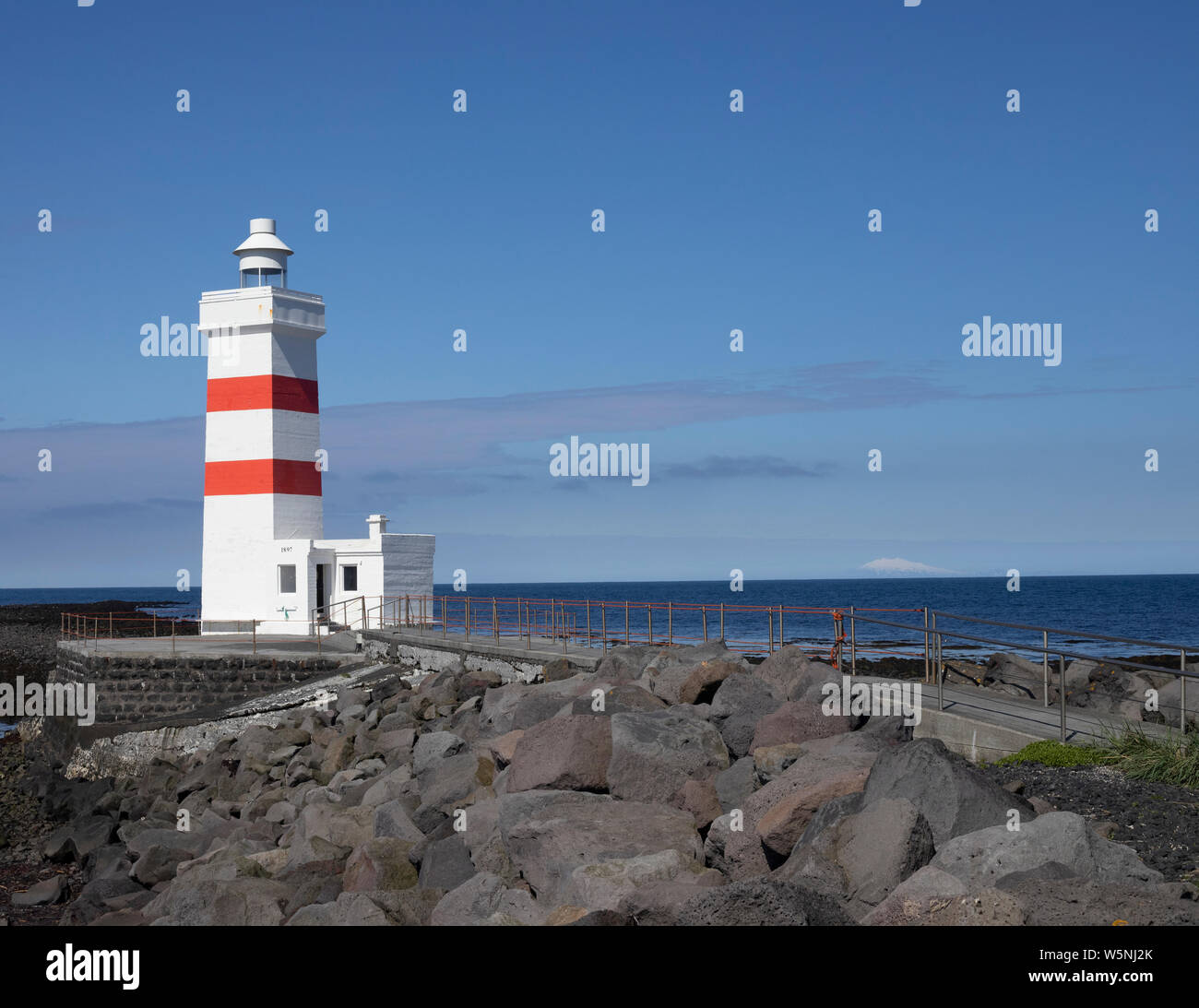 Old Gardur Lighthouse in Iceland Near Keflavik Airport. Beautiful seascape with dormant ice-caped volcano on the horizon. Photo taken around 11 AM Stock Photo