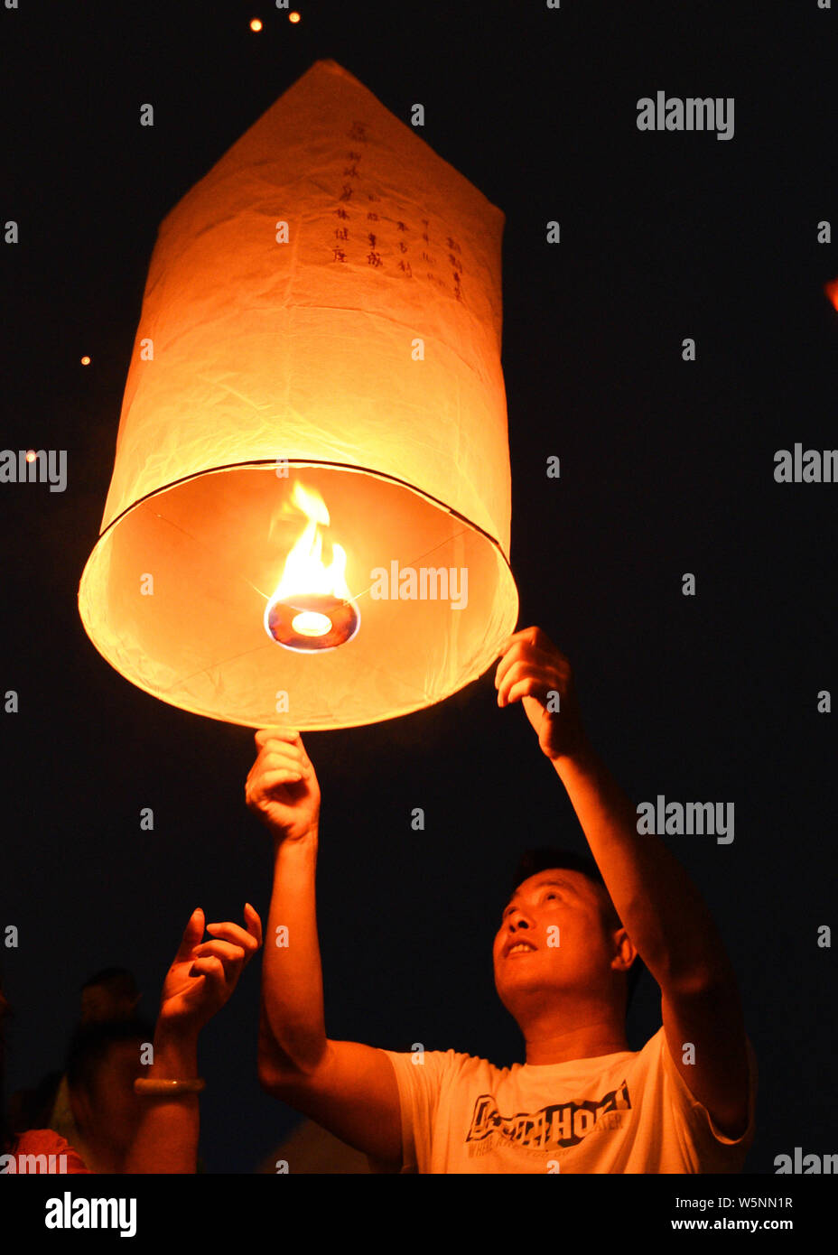 Tourists and people of Dai ethnic group release sky lanterns, also ...