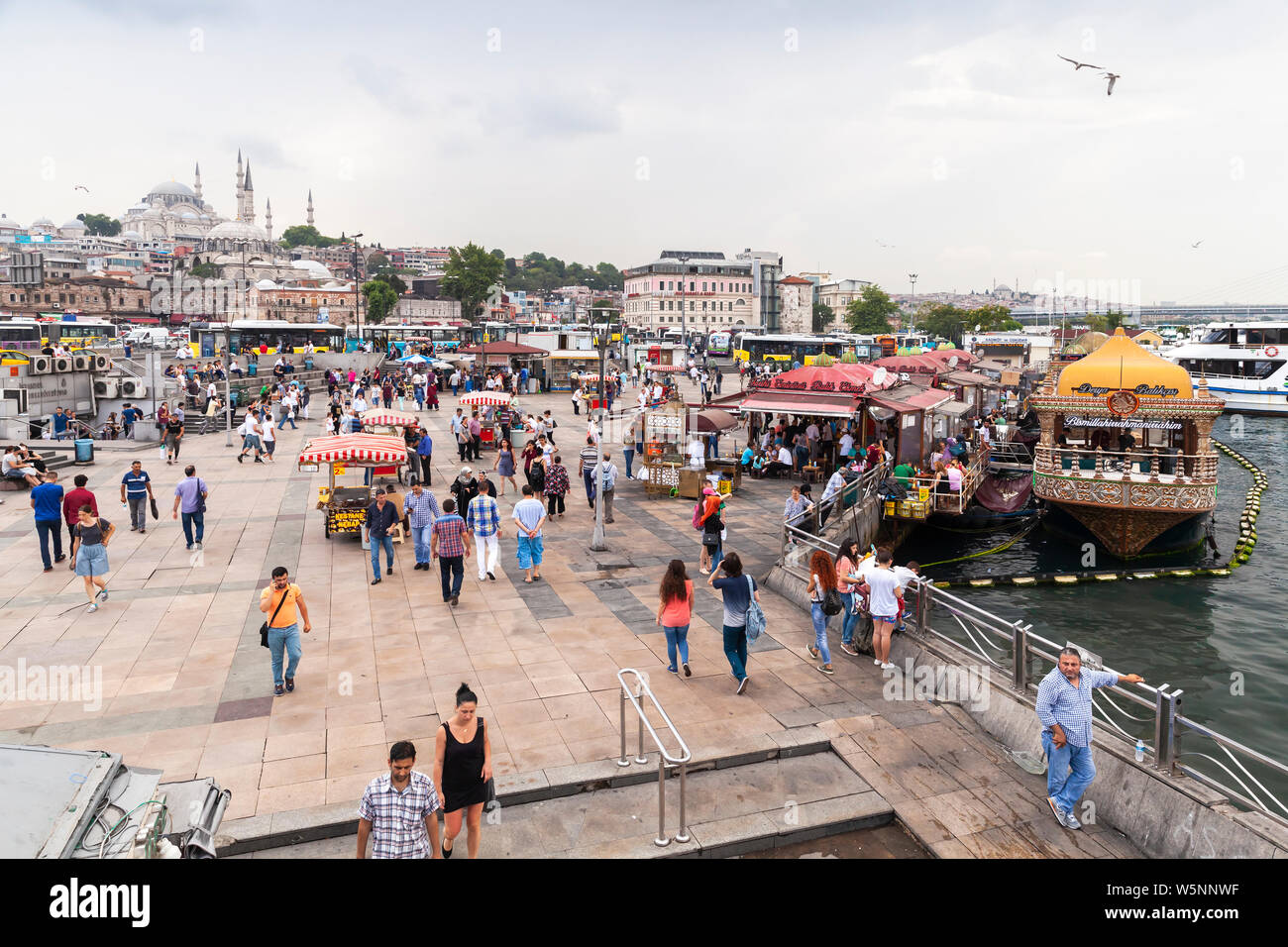 Istanbul, Turkey - June 26, 2016: Istanbul Cityscape, Eminonu district. People walk at the coast of Golden Horn Stock Photo