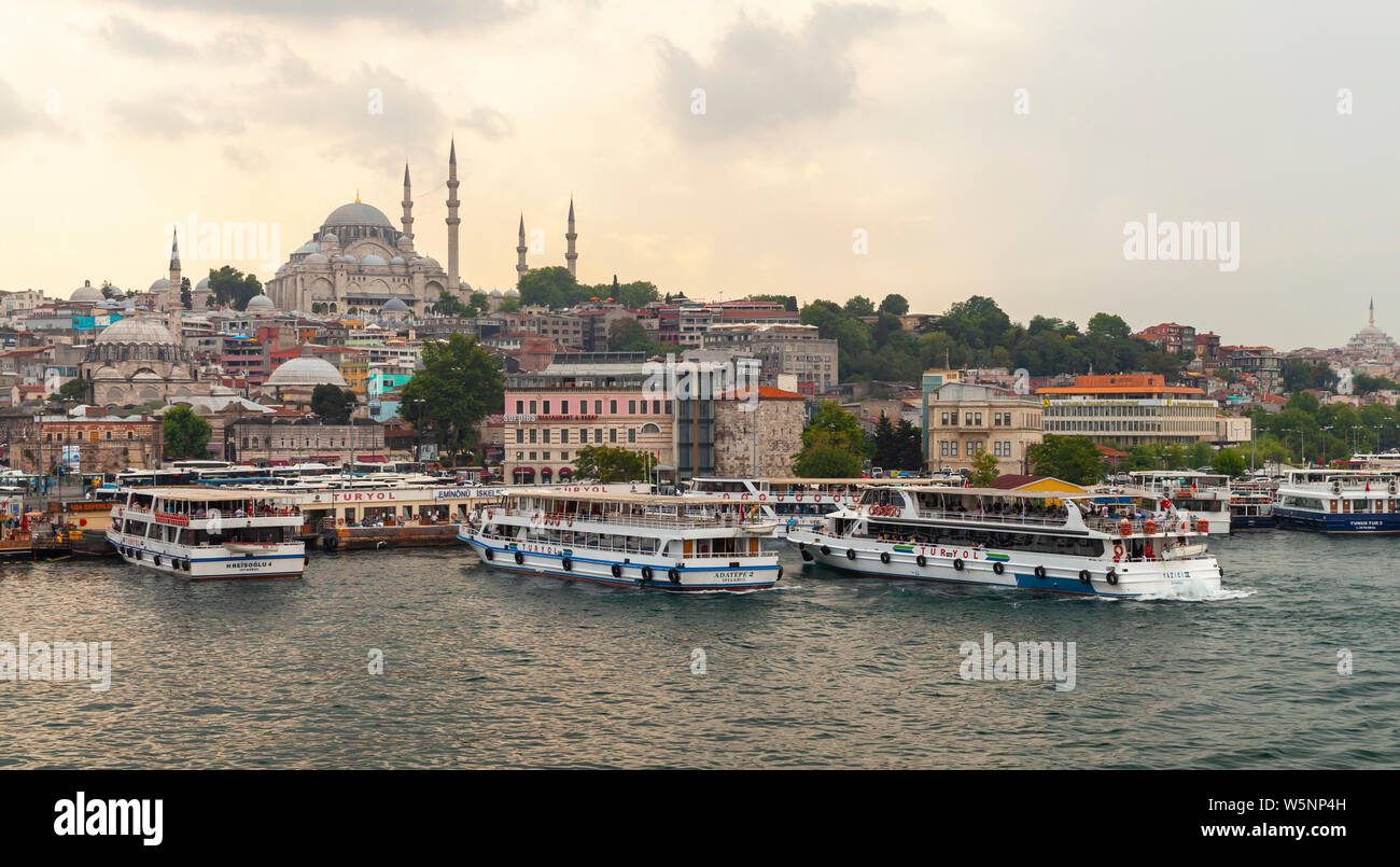 Istanbul, Turkey - June 26, 2016: Istanbul at evening, Eminonu district. People are on the coast of Golden Horn, Suleymaniye Mosque is on a background Stock Photo