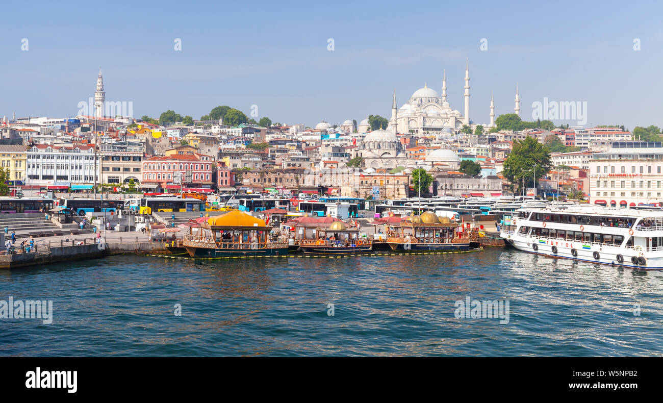 Istanbul, Turkey - July 1, 2016: Istanbul coastal panoramic cityscape, Eminonu district. People are on the coast of Golden Horn, Suleymaniye Mosque is Stock Photo