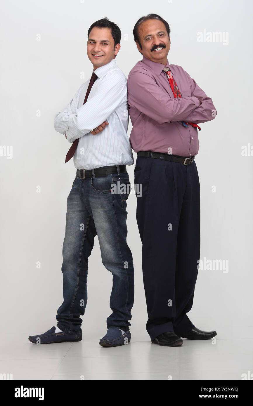 Two businessmen standing back to back with arms crossed Stock Photo - Alamy