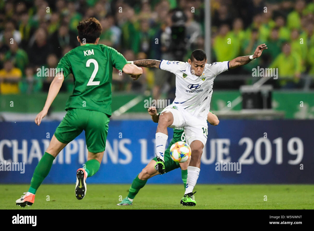 Ricardo Lopez, right, of South Korea's Jeonbuk Hyundai Motors F.C. dribbles against China's Beijing Sinbo Guoan F.C. in their 5th round of group G mat Stock Photo