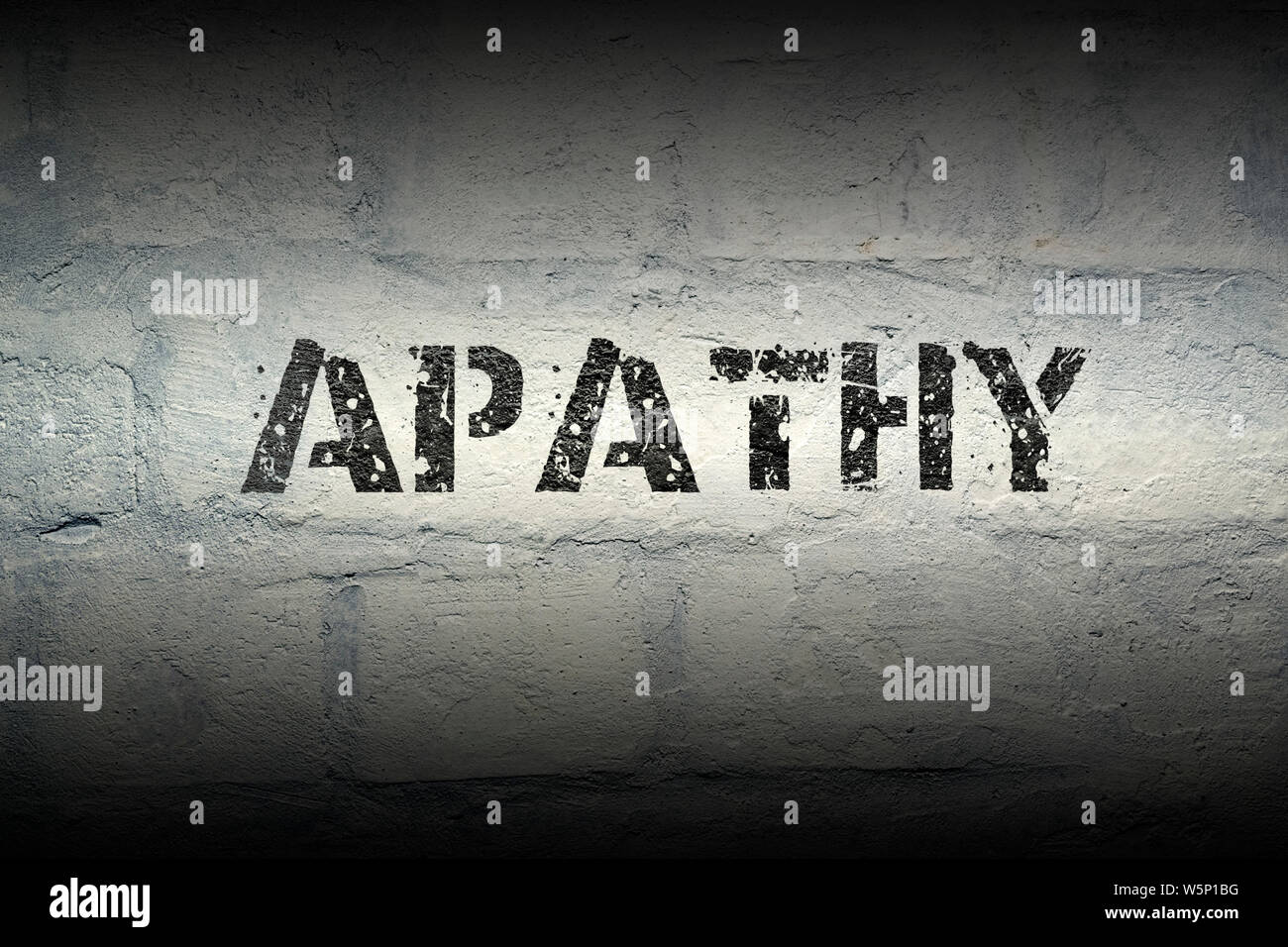 apathy stencil print on the grunge white brick wall Stock Photo