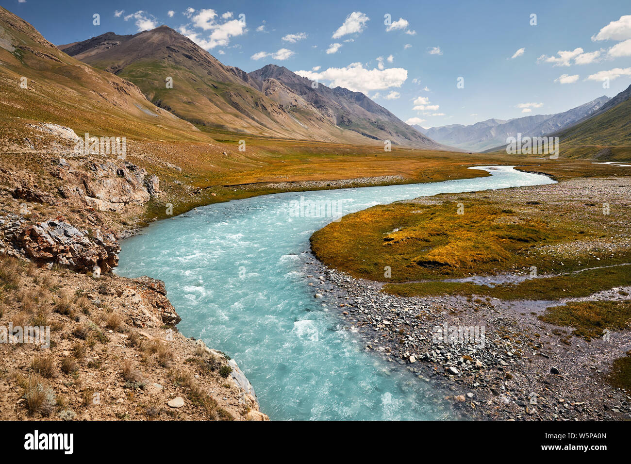 Beautiful river in the mountain valley against blue sky in Kyrgyzstan Stock Photo