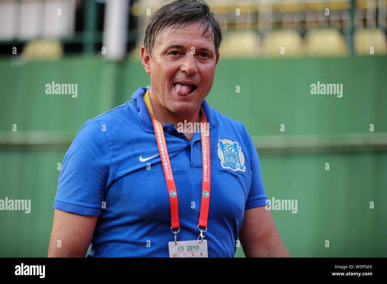 Head coach Dragan Stojkovic of Guangzhou R&F celebrates as he watches his players competing against Beijing Renhe in their 10th round match during the Stock Photo