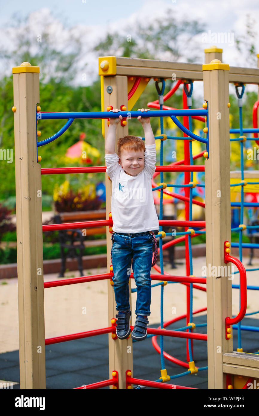Little boy playing on the playground in summer time Stock Photo - Alamy