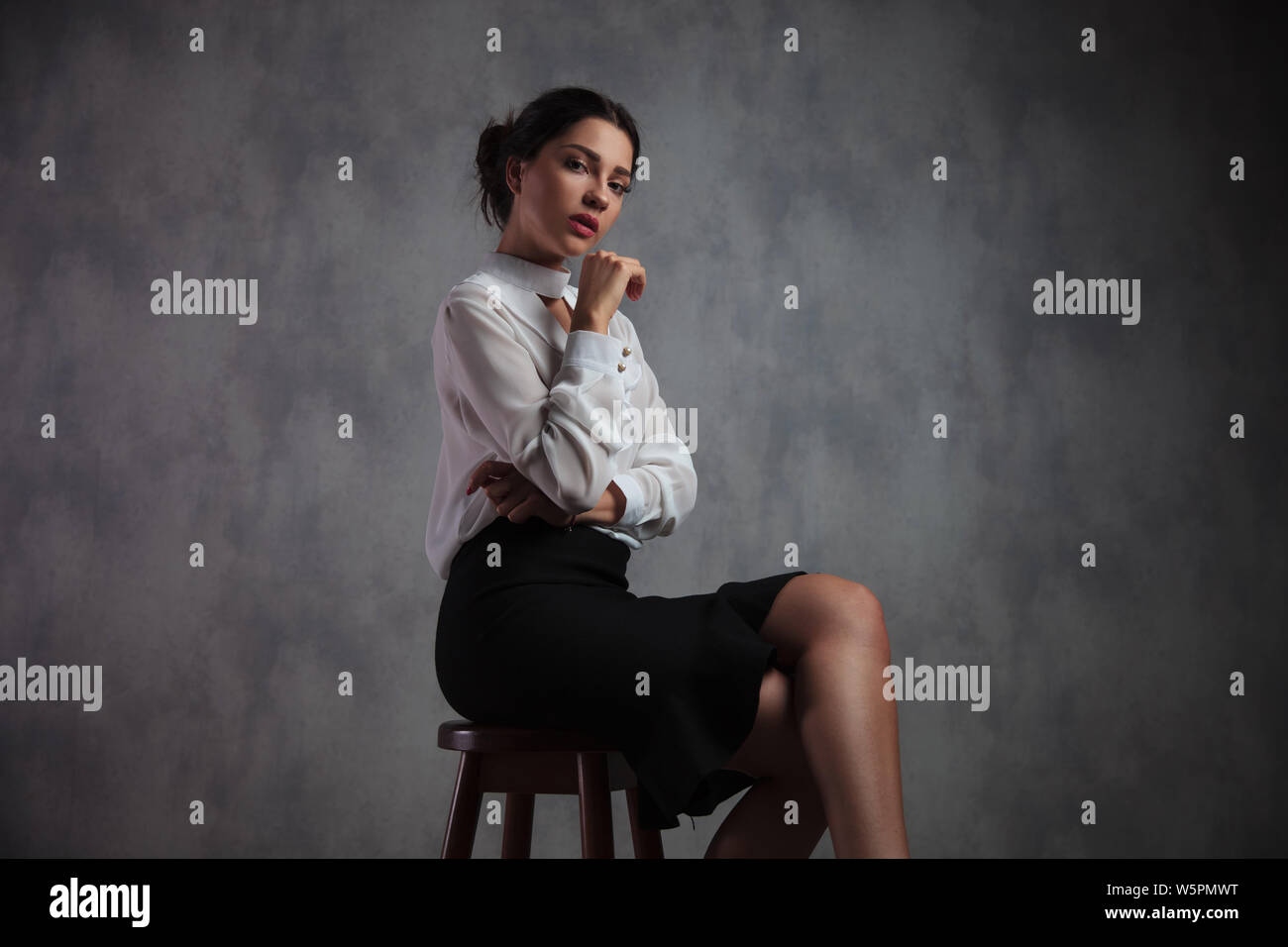 Portrait businesswoman sitting on stool hi-res stock photography and ...