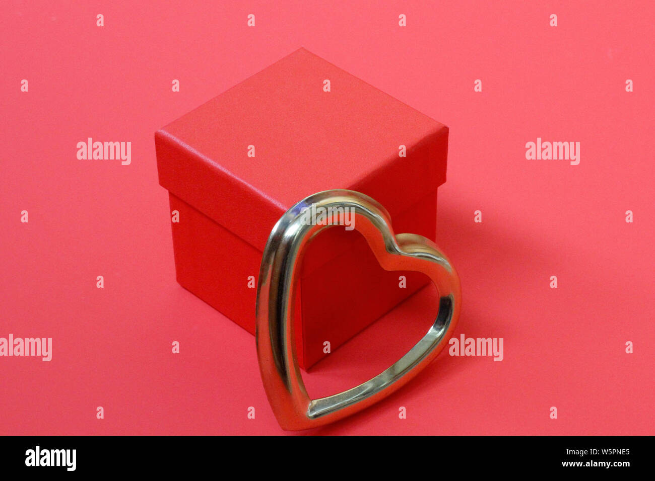 Red gift box with golden hearts. A gift for Valentines Day. The heart ...