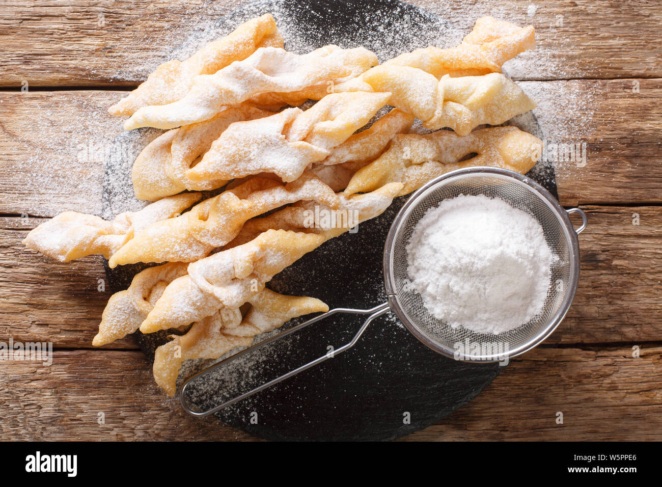Freshly made Angel Wings Cookies with powdered sugar close-up on the table. horizontal top view from above Stock Photo