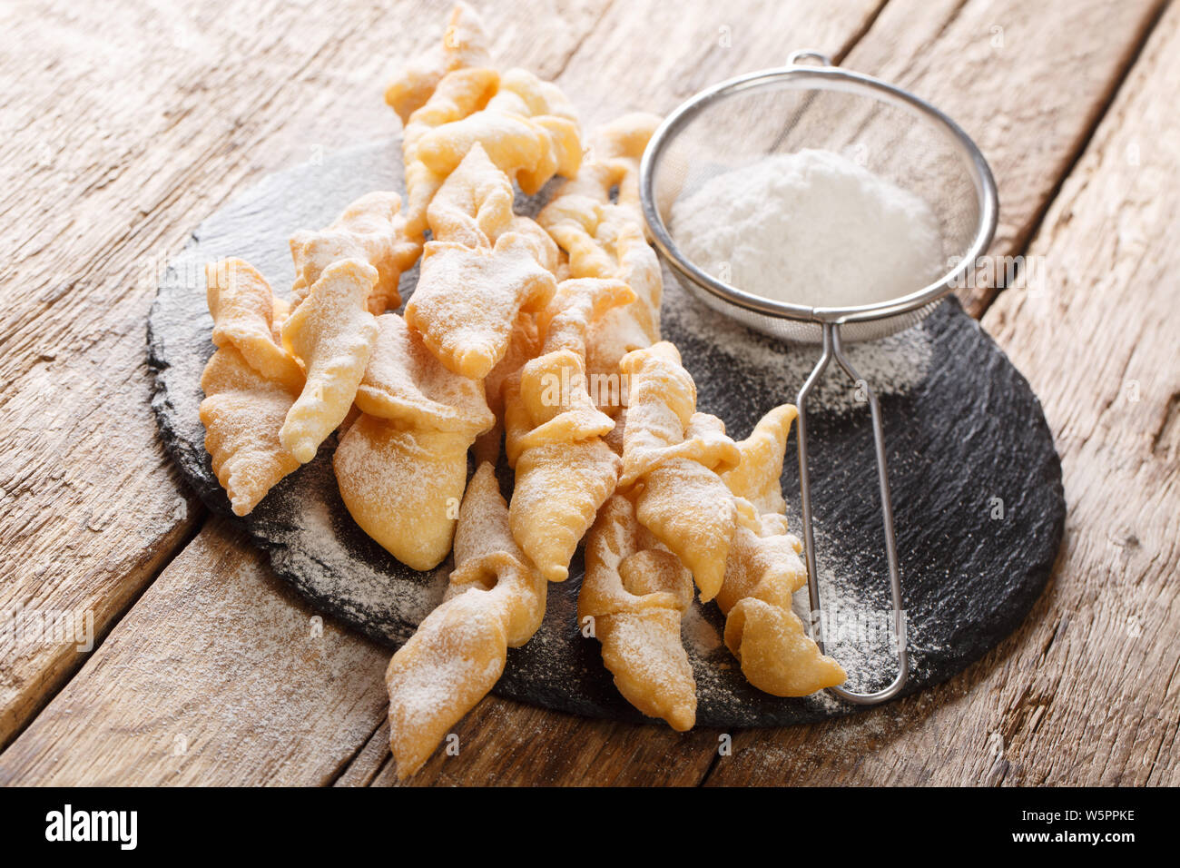 Angel wings (Faworki), cakes deep fried in oil to celebrate Fat Thursday close-up on the table. horizontal Stock Photo