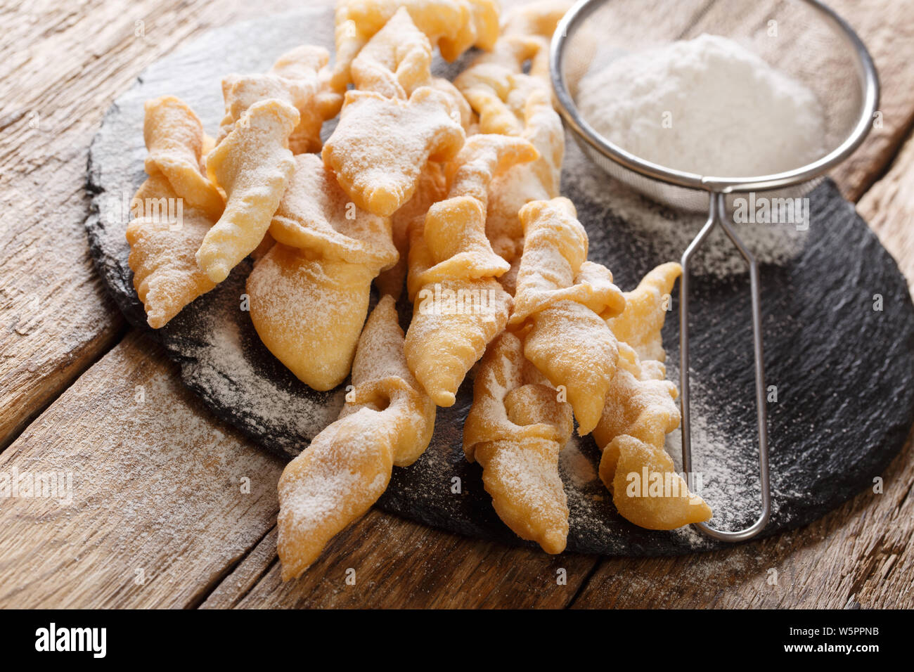 Freshly made Angel Wings Cookies with powdered sugar close-up on the table. horizontal Stock Photo