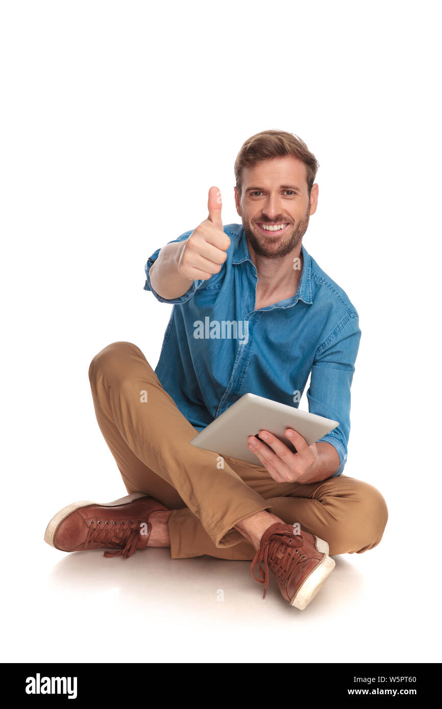 seated casual man working on tablet makes the ok sign on white ...