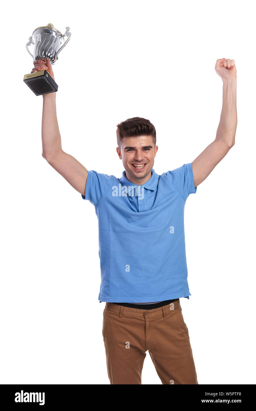 happy casual man holding trophy cup and hands in the air celebrating ...