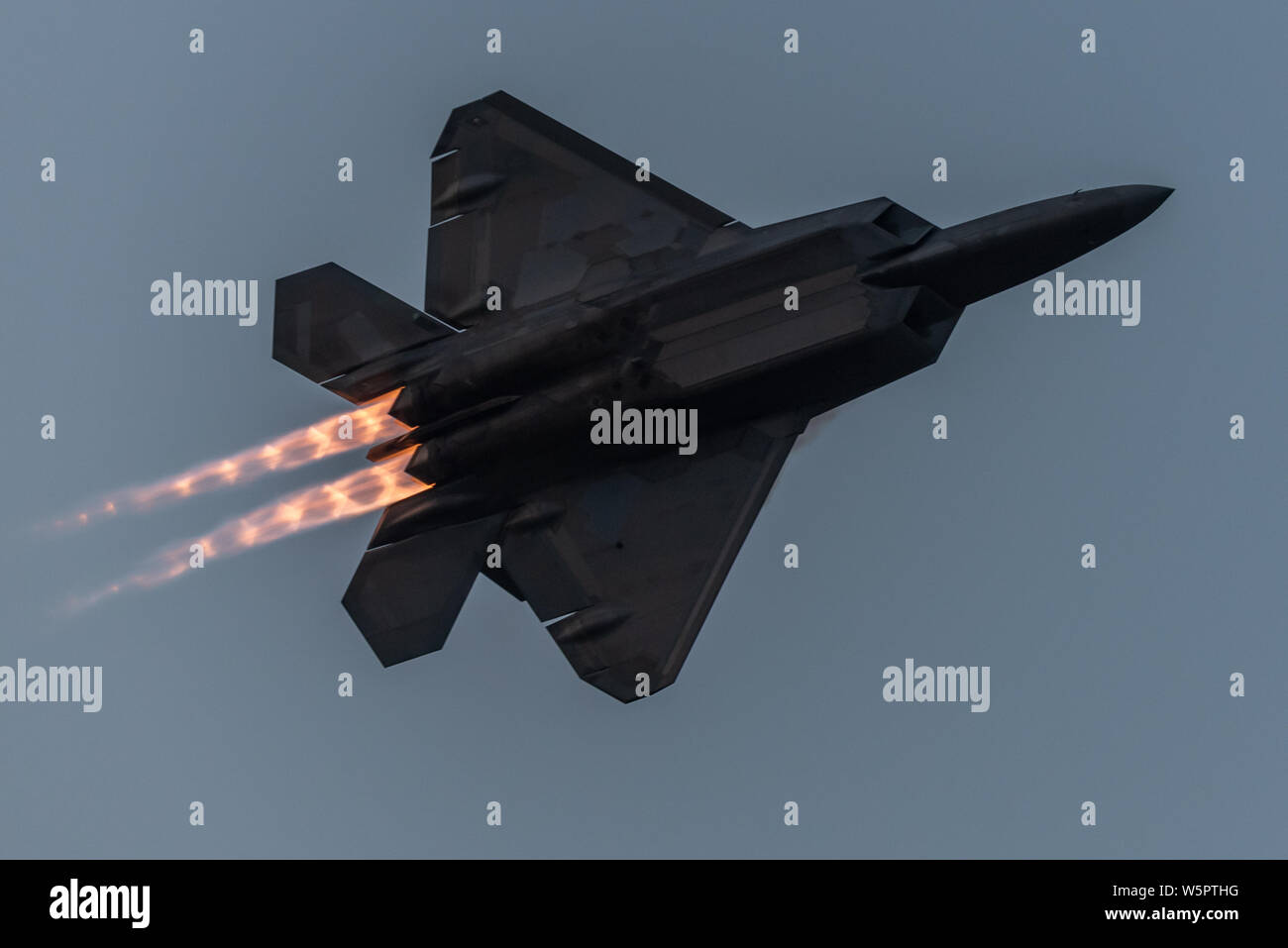 U.S. Air Force Maj. Paul Lopez, F-22 Demo Team commander, flies a twilight demonstration during EAA AirVenture in Oshkosh, Wis., July 28, 2019.  Founded in 2007, the F-22 Raptor Demo Team showcases the unique capabilities of the world's premier 5th-generation fighter aircraft. (U.S. Air Force photo by 2nd Lt. Samuel Eckholm) Stock Photo