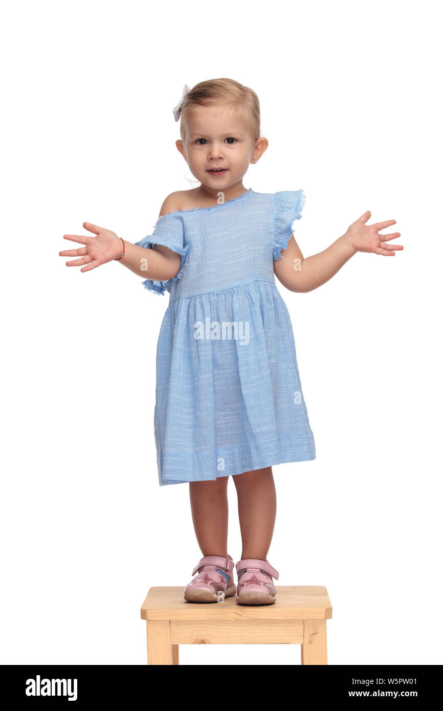 smiling little beautiful girl standing and showing her hands on white ...