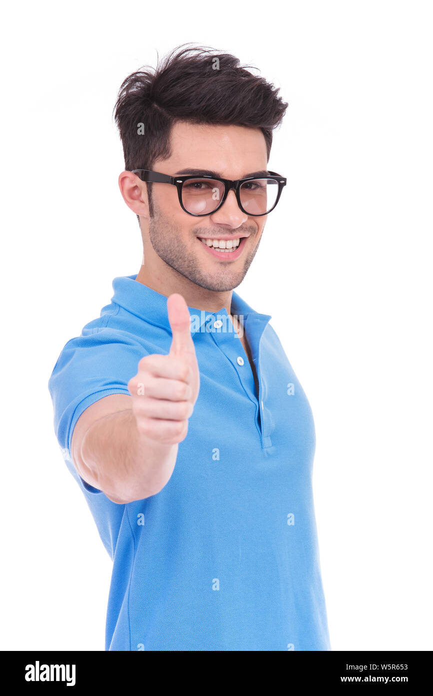 young casual man making the ok thumbs up hand sign on white background ...