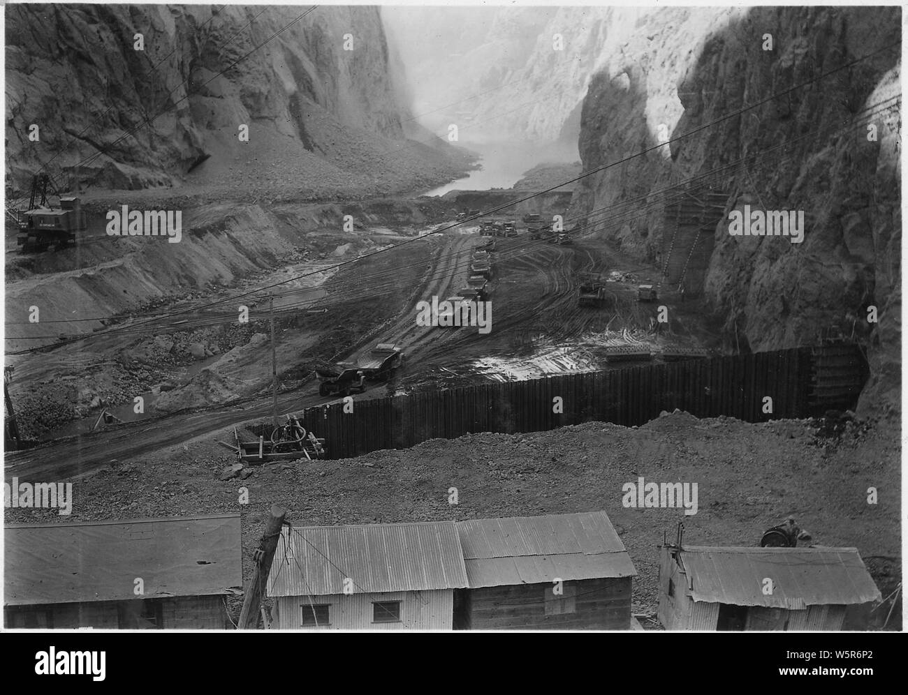 Looking downstream into upper cofferdam operations along Nevada abutment. Note percolation stops and interlocking steel sheet piling.; Scope and content:  Photograph from Volume Two of a series of photo albums documenting the construction of Hoover Dam, Boulder City, Nevada. Stock Photo