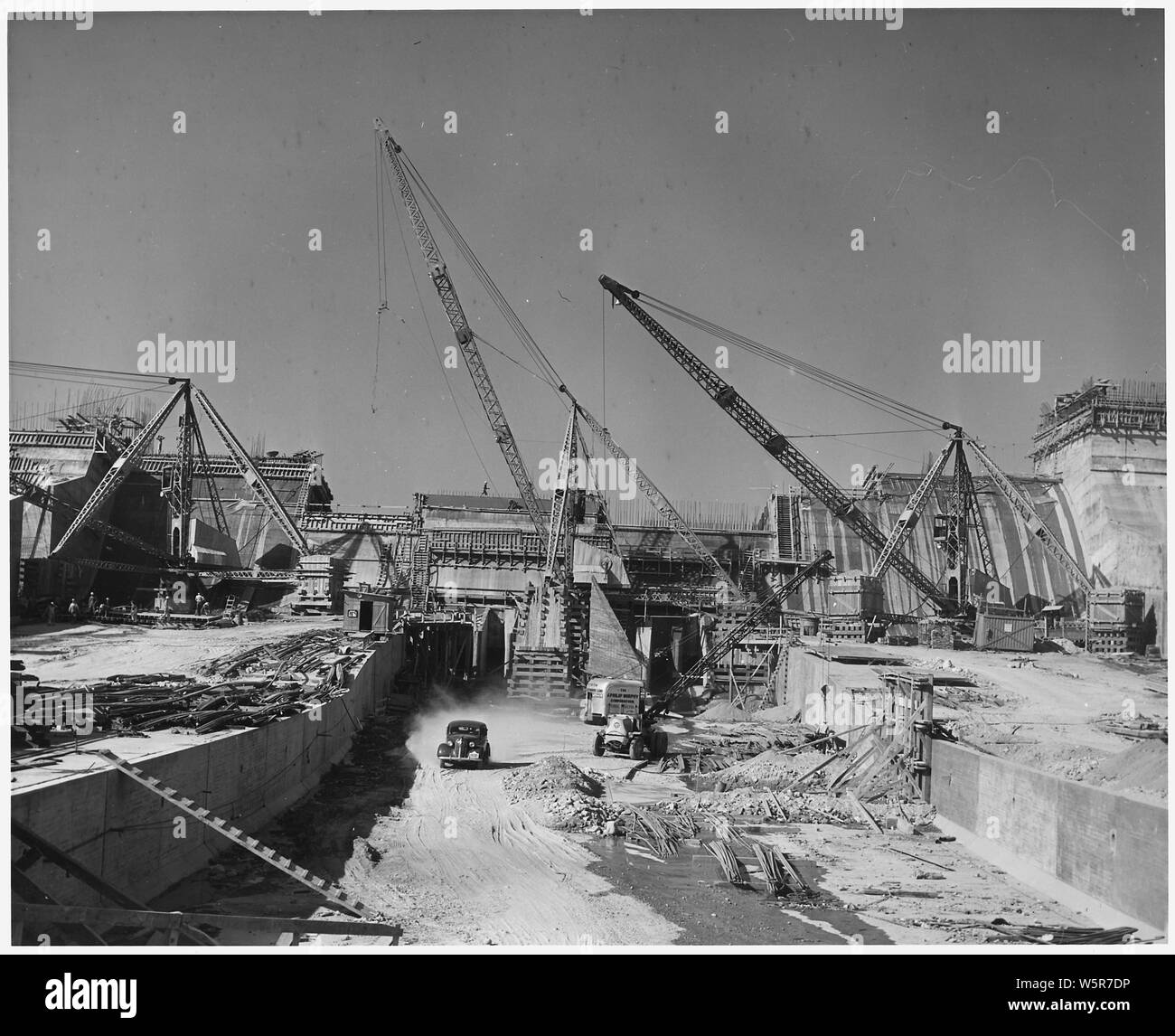 Looking upstream along the axis of the outlet channel showing the detail of construction. Note the arrangement of the stiff-leg derricks used in the construction of the ogee section seen in the background.   Project Los Angeles River Improvement. Location Hansen Dam across Tujunga Wash. Funds: Regular funds. Work prosecuted under Contract No. W-509-Eng.689. Stock Photo