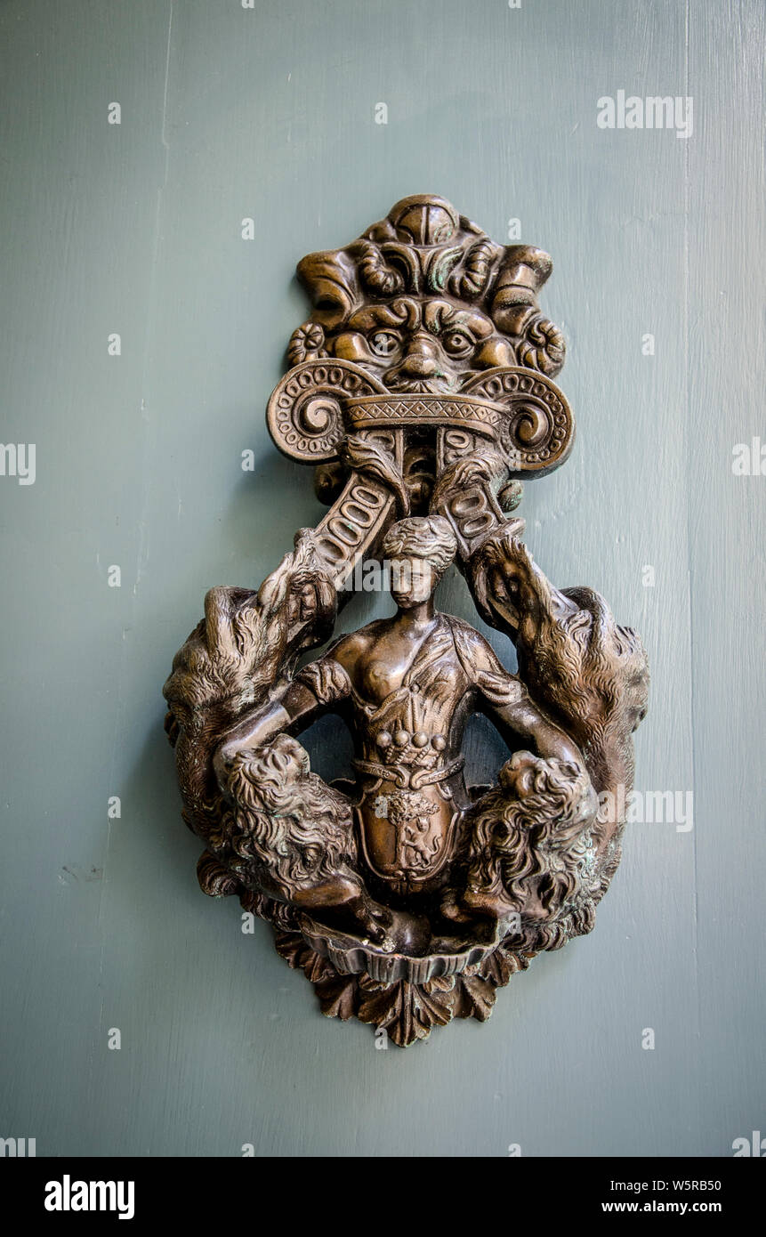 A decorative brass door knob in the form of a sculptured womans body