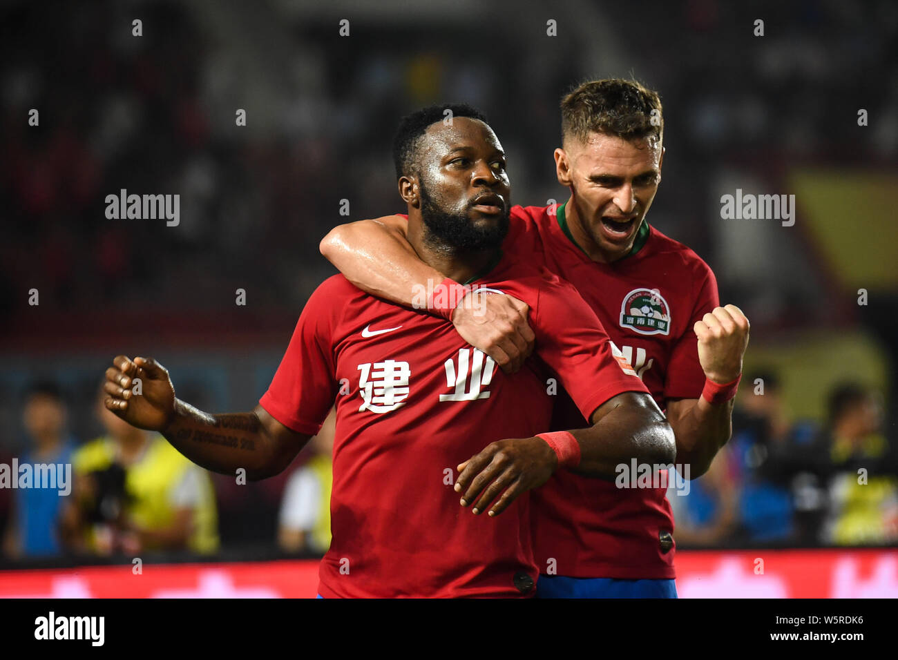 Cameroonian football player Franck Ohandza, left, of Henan Jianye celebrates with Brazilian football player Olivio da Rosa, also known as Ivo, after s Stock Photo