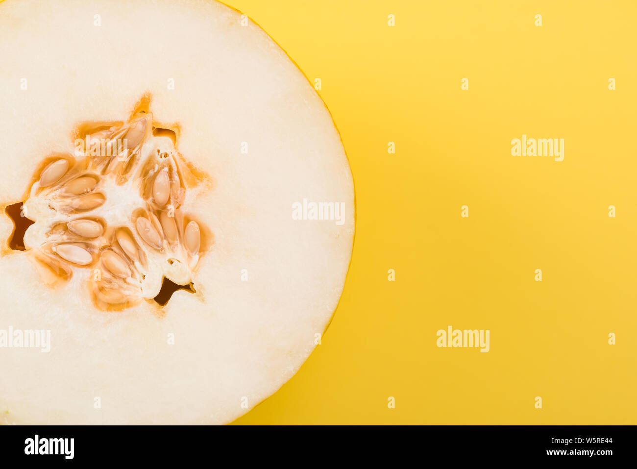 Yellow Musk Melon Sliced in Half on Pastel Background, Top View. Stock Photo