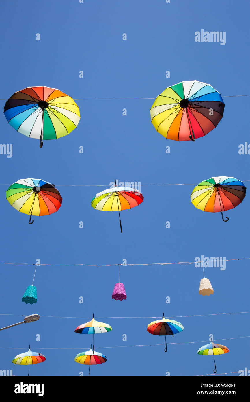 Colorful brollies suspended by wires over a street in Icmeler, Mugla province, Turkey Stock Photo