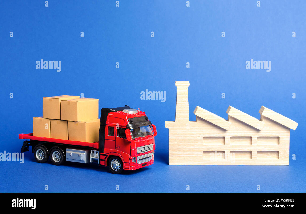 A red truck loaded with boxes stands near the factory. Services transportation of goods products, logistics in the industry, economic relations, infra Stock Photo
