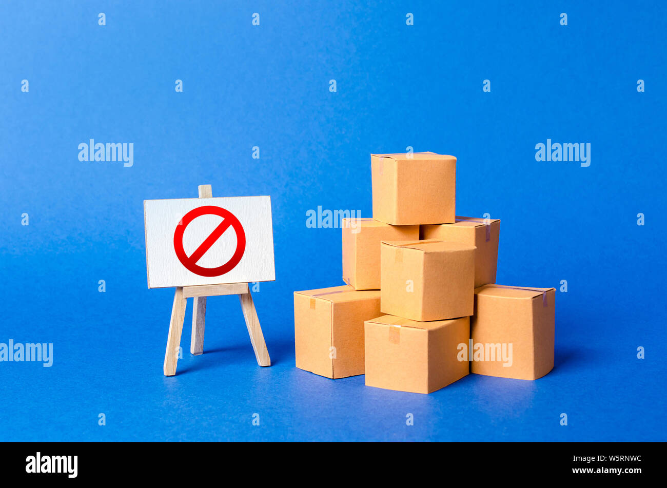 A stack pile cardboard boxes and a sign stand with red symbol NO. Restriction on the importation of goods, proprietary for business. Embargo, trade wa Stock Photo