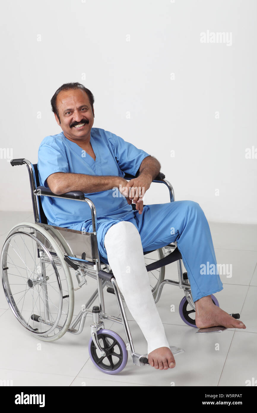 Portrait of a man with broken leg sitting in wheelchair Stock Photo - Alamy