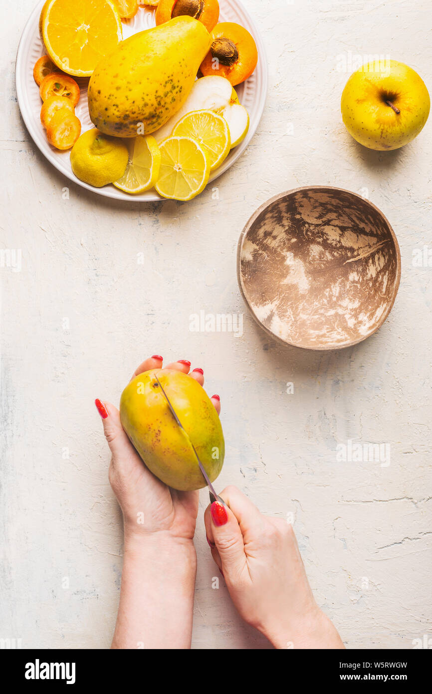 Mango preparation step by step. Female hands cut mango on white ...
