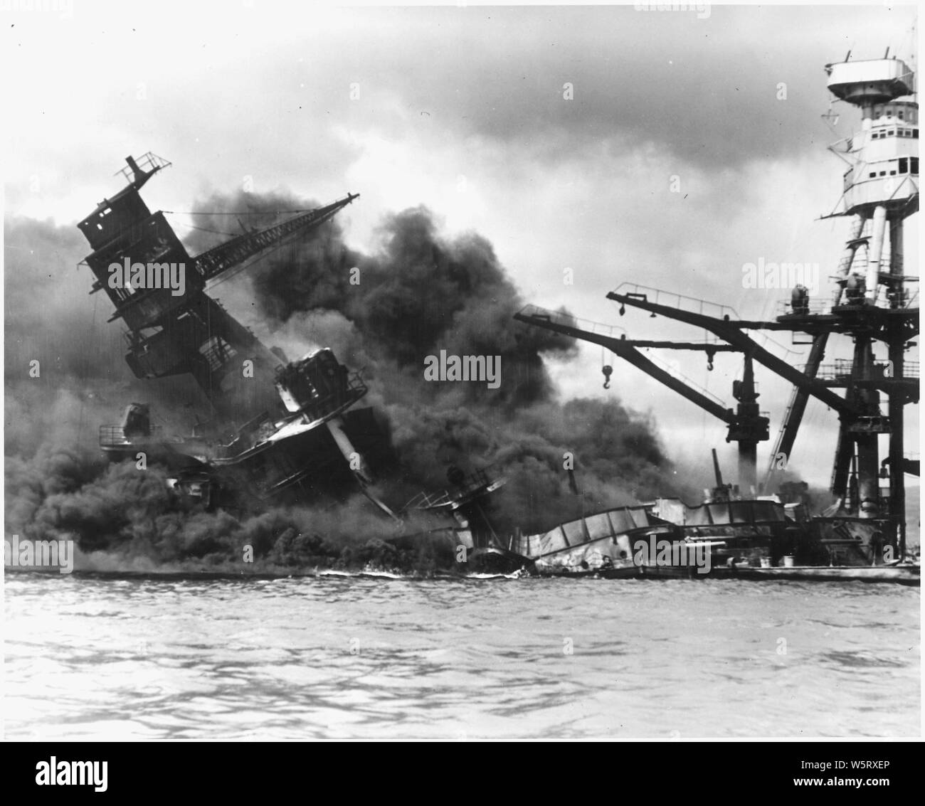 Naval photograph documenting the Japanese attack on Pearl Harbor, Hawaii which initiated US participation in World War II. Navy's caption: The battleship USS ARIZONA sinking after being hit by Japanese air attack on Dec. 7,1941.; Scope and content:  This photograph was originally taken by a Naval photographer immediately after the Japanese attack on Pearl Harbor, but came to be filed in a writ of application for habeas corpus case (number 298) tried in the US District Court, District of Hawaii in 1944. The case, In Re Lloyd C. Duncan related to imposition of martial law in Hawaii during World Stock Photo