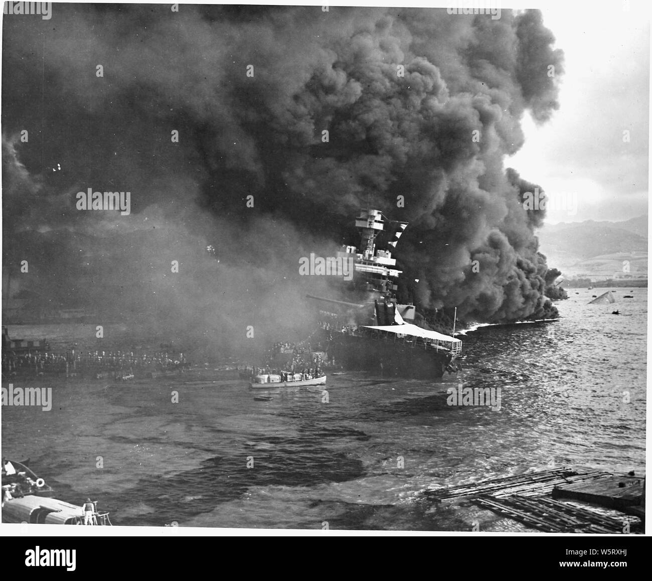 Naval photograph documenting the Japanese attack on Pearl Harbor, Hawaii which initiated US participation in World War II. Navy's caption: Abandoning ship aboard the USS CALIFORNIA after the ship had been set afire and started to sink from being attacked by the Japanese in their attack on Pearl Harbor on Dec. 7, 1941.; Scope and content:  This photograph was originally taken by a Naval photographer immediately after the Japanese attack on Pearl Harbor, but came to be filed in a writ of application for habeas corpus case (number 298) tried in the US District Court, District of Hawaii in 1944. T Stock Photo
