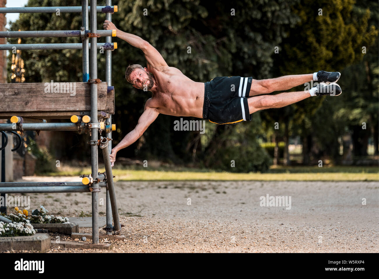 Fit Muscular man performing calisthenics fitness workout on outdoor ...
