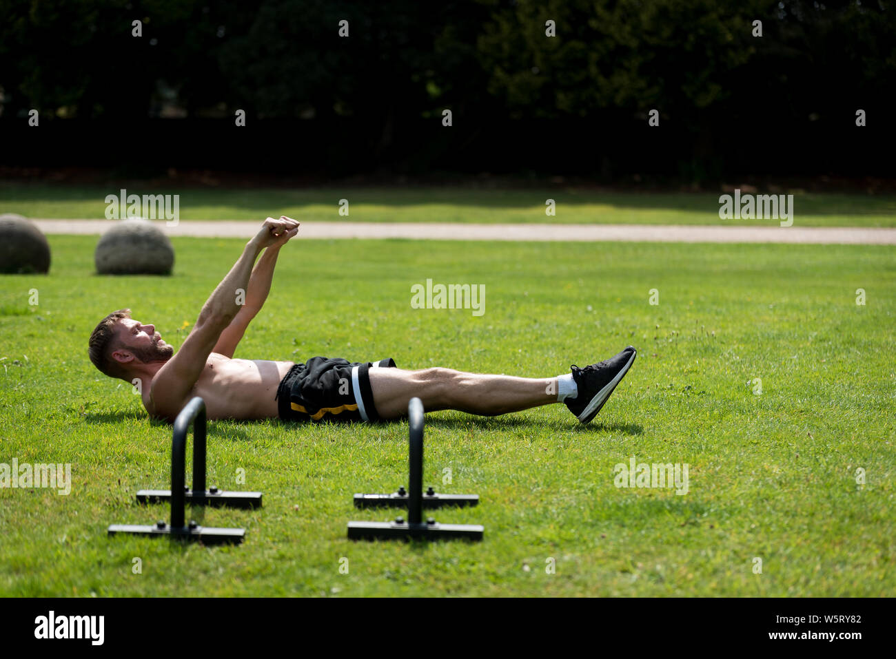 Man performing warm up before doing calisthenics fitness workout in an ...