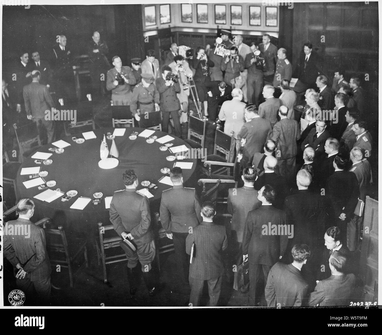 Participants in the Potsdam Conference in Germany stand mingling in the conference room at Cecilienhof Palace. The Big Three, President Harry S. Truman, British Prime Minister Winston Churchill, and Soviet leader Josef Stalin pose for cameramen at the top of photo. Stock Photo