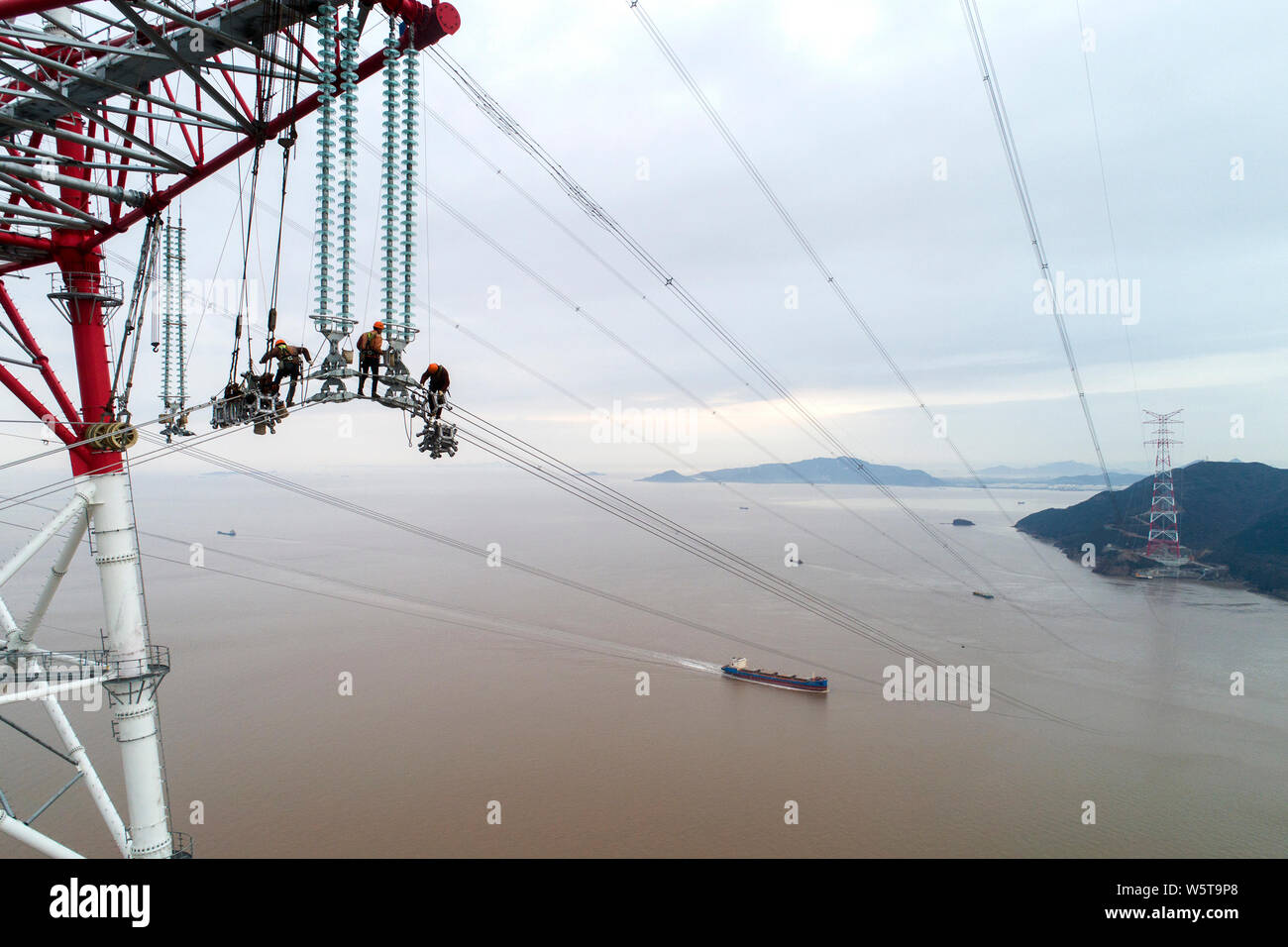 Chinese workers assemble power cables to connect Zhoushan's Jintang and  Cezi islands with a distance of 2,656 metres at the 380-metre tall  electricity Stock Photo - Alamy