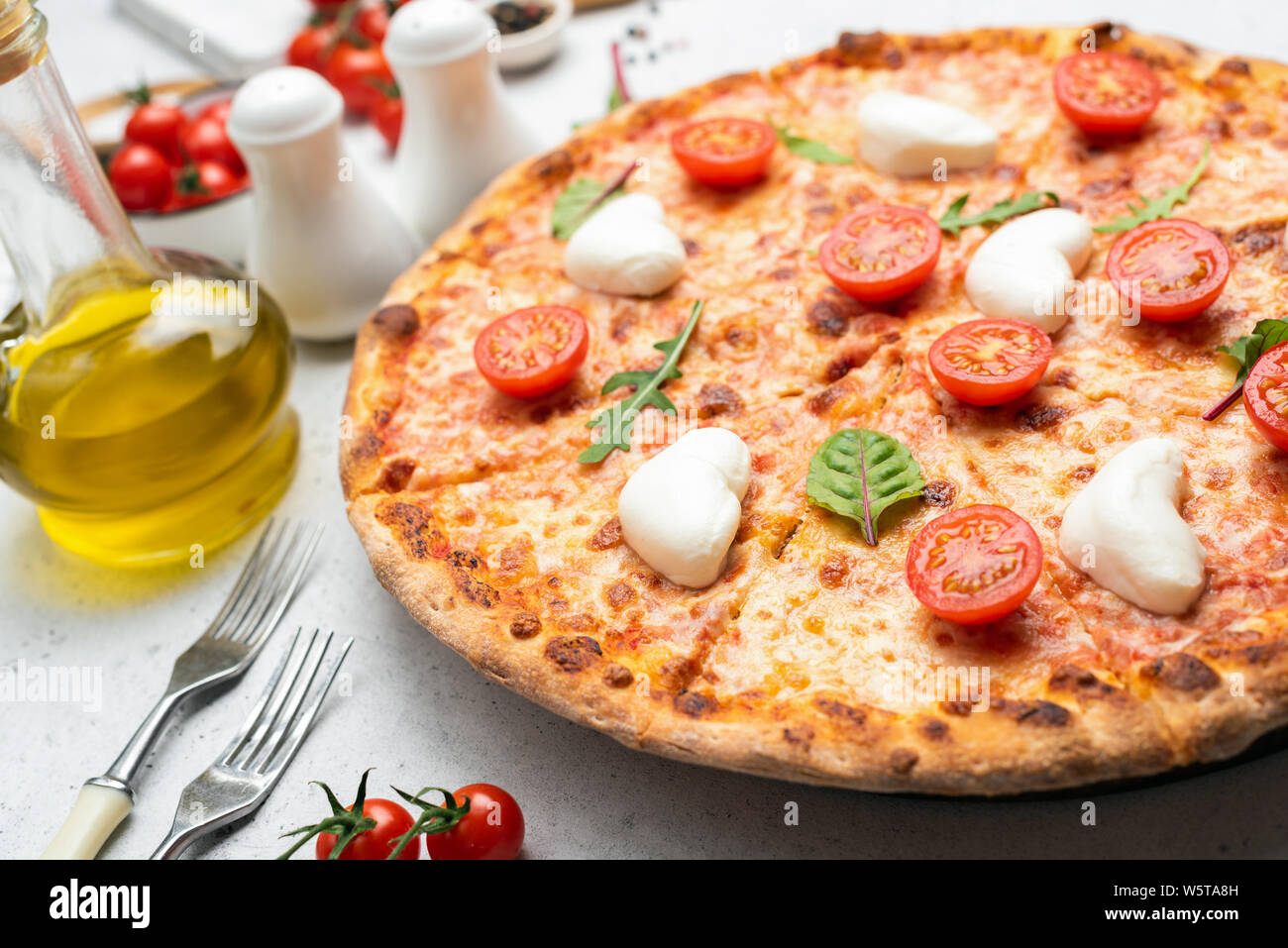 Italian pizza with mozzarella cheese and cherry tomatoes, closeup angle view Stock Photo